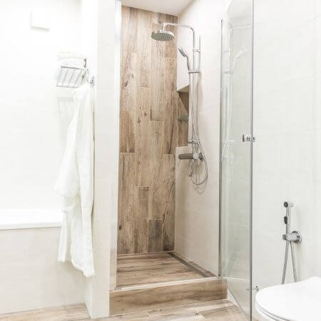 Bathroom with shower, toilet, and wooden floor in a contemporary setting.