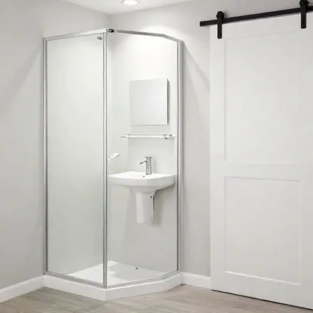 A compact corner glass shower enclosure next to a small wall-mounted sink.