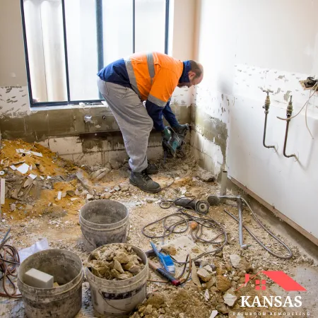 Contractor cutting into the bathroom wall during demolition work.