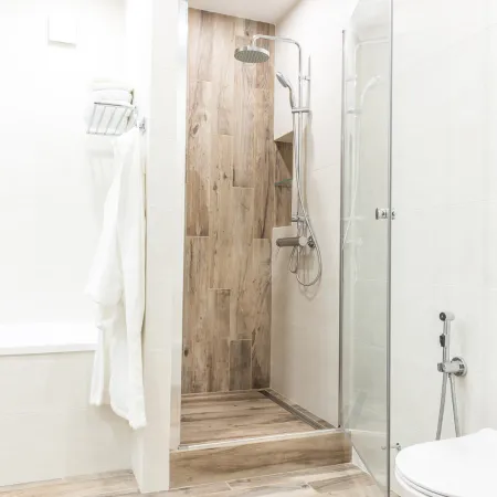 Modern walk in shower with wood look tile and glass door.